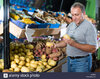 glad-man-is-choosing-potato-in-the-vegetables-store-M9BBP2.jpg