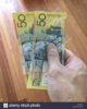 two-fifty-australian-dollar-notes-held-in-hand-S1PNEM.jpg